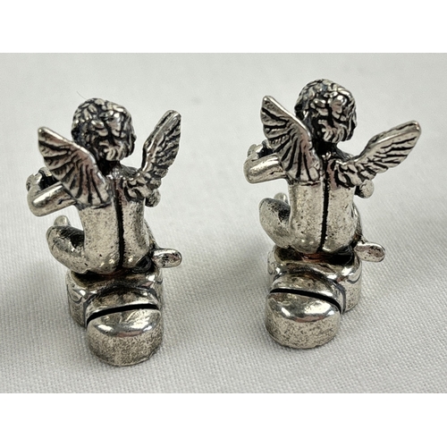 1186 - A set of 6 small silver plated place card holders modelled as cherubs. Each approx. 2.5cm tall.