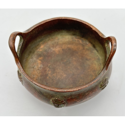 1266 - A small Chinese bronze 2 handled censor raised on tripod feet, with embossed characters to outer bow... 