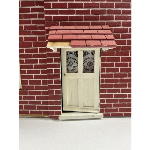 1281 - A large wooden fully furnished dolls house with red brick finish. Fully fitted with electrical light... 