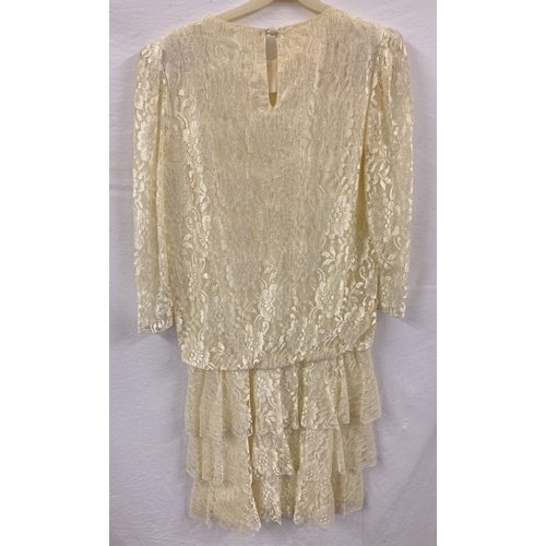 1998 - A vintage 1980's cream lace ruffle skirt dress by Hamells, on original hanger. Long sleeved with sco... 