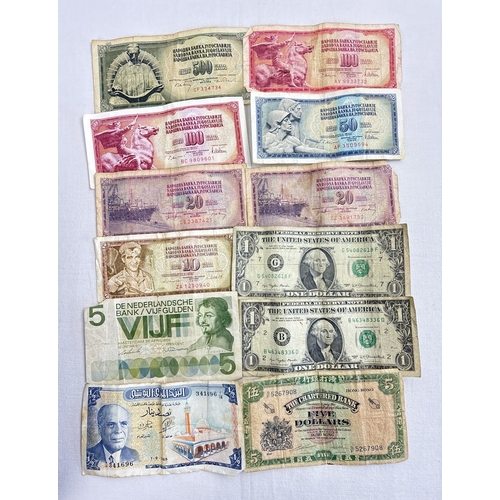 23 - 12 foreign bank notes in varying conditions to include examples from Tunisia, Hong Hong, Netherlands... 