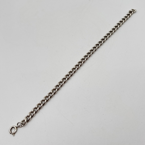 1115 - A 7.5 inch silver curb chain bracelet with spring ring clasp. Marked Sterling to clasp and lion mark... 