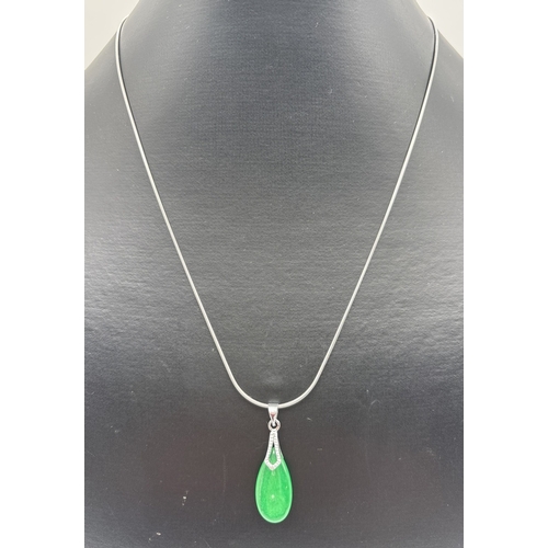 1130 - A modern teardrop shaped apple green jadeite pendant with 18ct white gold plated mount and bale. On ... 