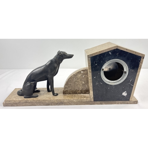 1367 - An Art Deco marble mantle clock of stylised design, mounted with spelter dog figurine. Modelled with... 