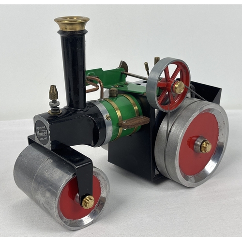 A Mamod steam powered model of a steamroller with front wheel plough attachment and accessories.