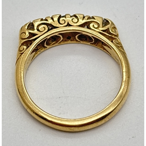 1002 - An Edwardian style 18ct gold ring set with 5 graduating sized diamonds. Pierced scroll work mount wi... 