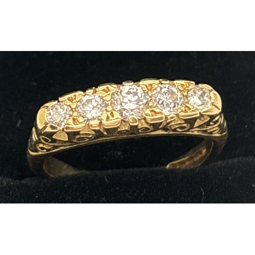 1002 - An Edwardian style 18ct gold ring set with 5 graduating sized diamonds. Pierced scroll work mount wi... 