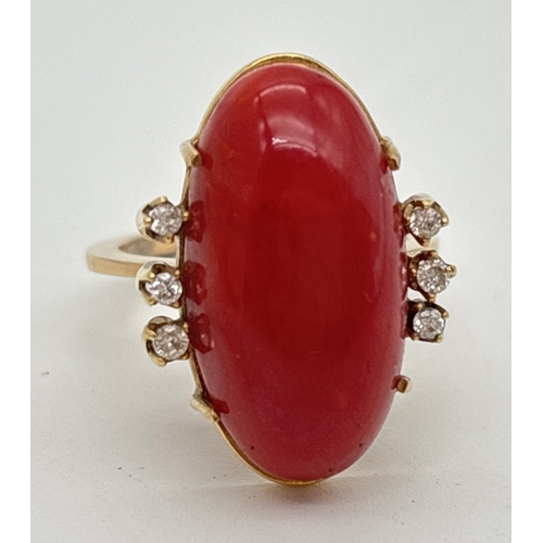 1008 - A 14ct gold vintage red coral and diamond cocktail ring. Large central oval coral cabochon with 3 sm... 