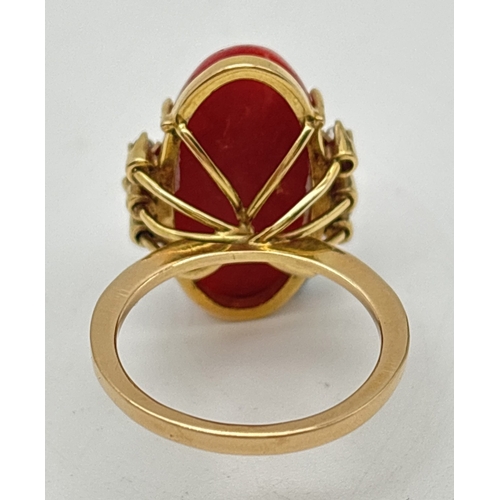 1008 - A 14ct gold vintage red coral and diamond cocktail ring. Large central oval coral cabochon with 3 sm... 