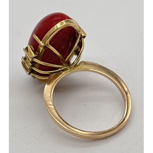 1008 - A 14ct gold vintage red coral and diamond cocktail ring. Large central oval coral cabochon with 3 sm... 