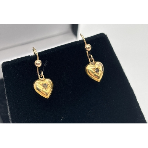 1010 - A pair of vintage 9ct gold heart drop earrings each set with a small clear stone. Gold marks on post... 