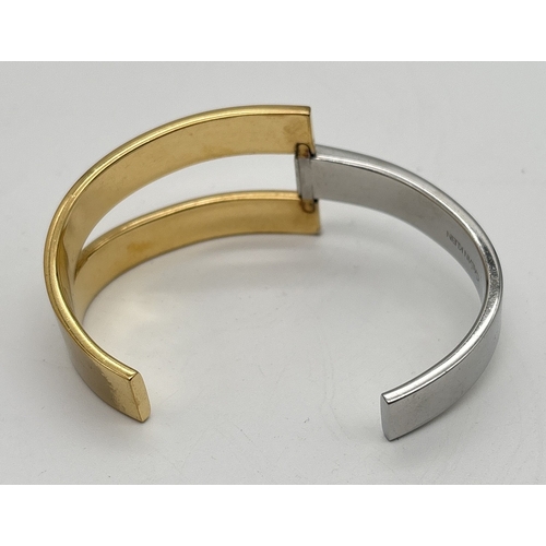 1017 - A modern design silver and gold tone cuff bangle by Calvin Klein. Designer name stamped inside.