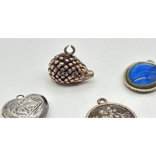 1026 - 8 silver and white metal pendants/charms in various sizes. To include a heart shaped locket with eng... 