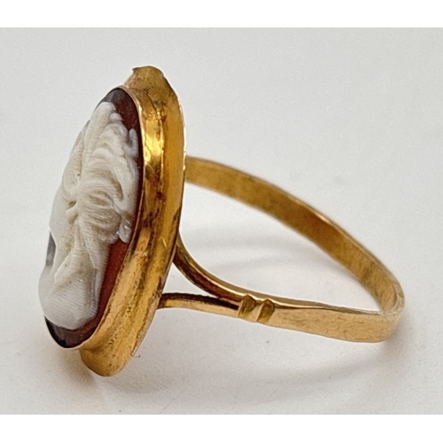 1035 - A yellow metal oval shaped cameo ring with split shoulders and plain shank. Unmarked but tests as 9c... 