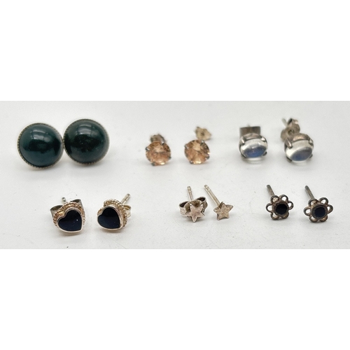 1063 - 6 pairs of silver and white metal studs style earrings. To include circular studs set with peach sto... 