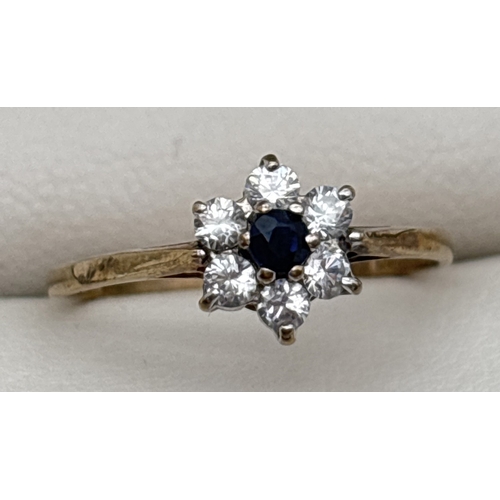 1070 - A 9ct gold, sapphire and cubic zirconia ring with flower head design mount. Small central round cut ... 