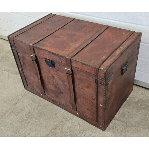 1433 - A large light weight wooden cabin trunk with metal handles and leather strap buckle detail. Approx. ... 