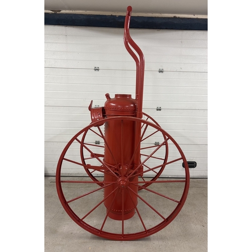 An antique hand drawn mobile chemical fire extinguisher as used in large homes, schools & office buildings in the late 19th century. Has been repainted. Hose is missing. Wheels approx. 128cm diameter.