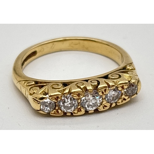 An Edwardian style 18ct gold ring set with 5 graduating sized diamonds. Pierced scroll work mount with decorative detail to both shoulders. Central 0.10ct diamond with 2 smaller diamonds either side. Total diamonds approx. 0.25ct. Size L, total weight approx. 5g.