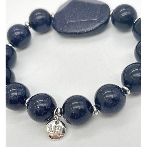 1015 - A blue sandstone elasticated bracelet by Lola Rose. Round sandstone beads with alternating silver to... 