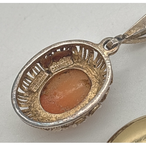 1037 - 2 vintage pendants. A rolled gold oval locket with floral engraved decoration to front, together wit... 