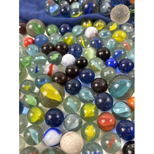 39 - A collection of glass marbles in various sizes, colours & designs to include cats eye, opaque swirli... 