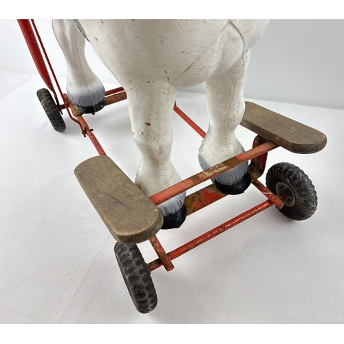 42 - A vintage 1950's child's push along/ride on horse by Tri-ang. A painted white hard plastic horse on ... 