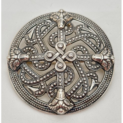 A mid-century Scandi silver shield brooch with pierced design by Kalevala Koru of Finland. Fully hallmarked to reverse with Makers mark, 916 silver mark and dated for 1968. In original box. Approx. 5cm diameter.