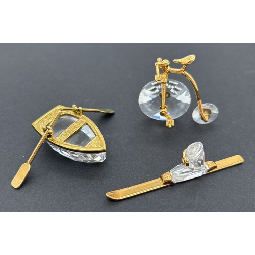 3 retired Swarovski Crystal Memories ornaments with gold coloured metal detail. A ski from “In a class of their own” series, a rowboat from “In the Realms of Fantasy and Fairy Tales” theme - with removable oars, and a Penny Farthing bicycle from the “Times Past” series. All retired in 1998 & 1999. Unboxed.