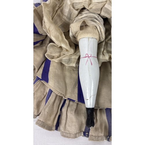 259 - A large antique ceramic head French doll with soft body and ceramic arms and legs. With hand painted... 