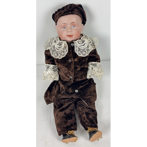 261 - A German Gebruder Knock bisque head boy doll in brown velvet trousers and jacket. Straw filled body ... 