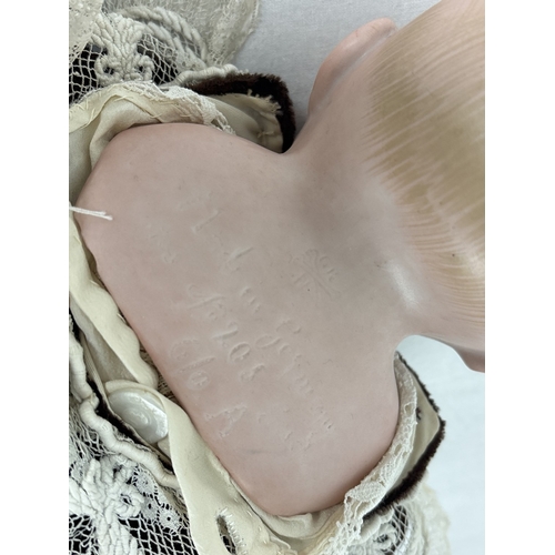 261 - A German Gebruder Knock bisque head boy doll in brown velvet trousers and jacket. Straw filled body ... 