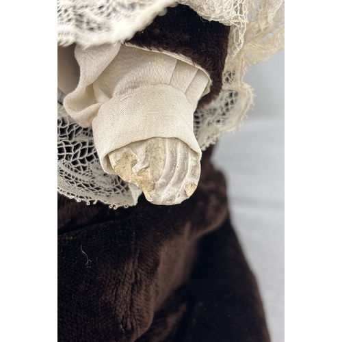 261 - A German Gebruder Knock bisque head boy doll in brown velvet trousers and jacket. Straw filled body ... 