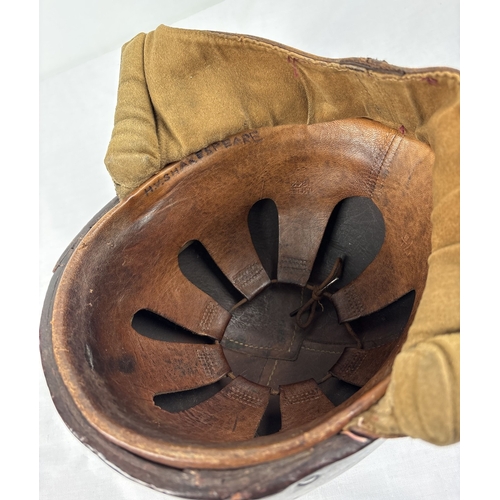 1266 - A World War II era leather pudding basin motorcycle helmet with integral leather neck, ear flaps and... 