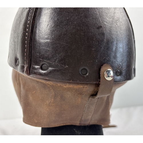 1266 - A World War II era leather pudding basin motorcycle helmet with integral leather neck, ear flaps and... 