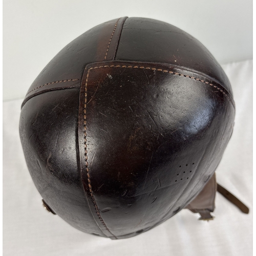 1266 - A World War II era leather pudding basin motorcycle helmet with integral leather neck, ear flaps and... 