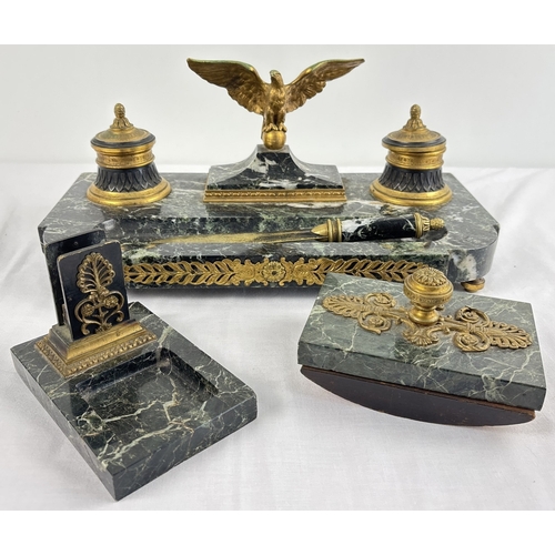 An antique marble and bronze encrier/inkstand in an empire style, with accessories. Inkstand has two decorative lidded inkwells with central bronze eagle figure. Pen rest to front of stand with foliate bronze plaque to font edge, marble base rests on 4 bronze bun style feet. Comes with a marble handled letter opener, an ink blotter and matchbox holder with ashtray - all with bronze decoration. Inkstand approx. 17 x 42cm.