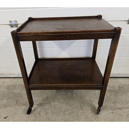1338 - A pair of mid century bow back smokers together with a vintage dark wood 2 tier tea trolley with cas... 