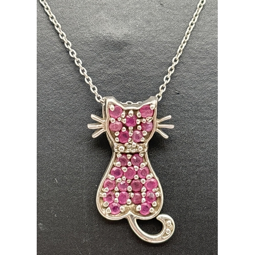 A silver, ruby and diamond pendant necklace modelled as a sitting cat, on an 18" fine belcher chain. Set with 22 small round cut rubies and a single round cut diamond to tail. 925 stamped on back of pendant and spring ring clasp. Pendant approx. 2cm long.