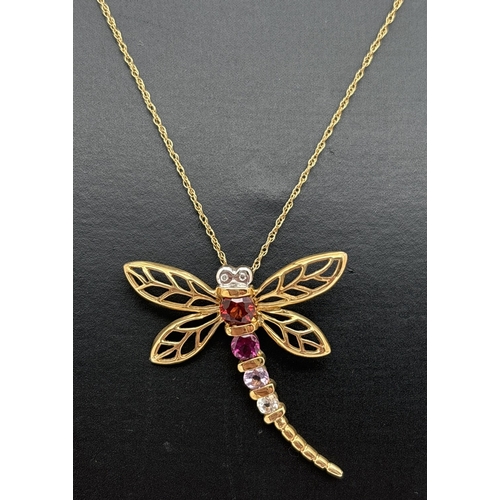 A boxed 9ct gold gemstone set dragonfly pendant necklace with an 18" fine rope chain. Dragonfly body set with a round cut garnet, rhodolite garnet, amethyst and white spinel stone in graduating sizes, with 2 small bezel set diamonds for eyes. Pierced work detail to all 4 wings. Back of pendant, spring ring clasp and fixing plate all stamped 375. Pendant approx. 3 x 2.5cm. Total weight approx. 2.4g.