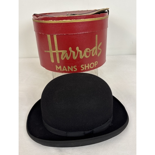 A vintage Harrods black felt bowler hat, in a red Christy's London Hats/Harrods Mans Shop hat box with gilt detailing.