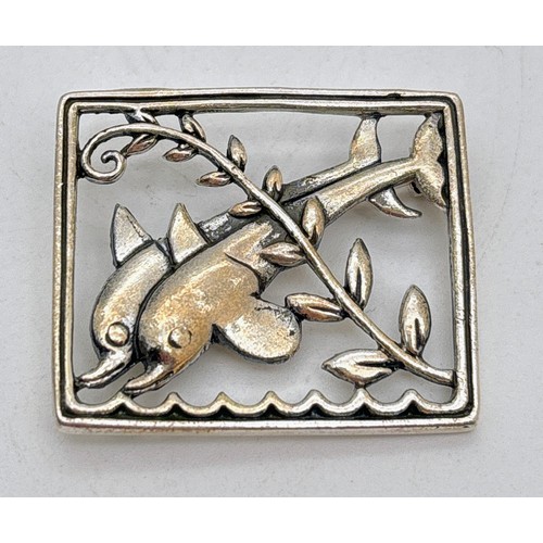A sterling silver rectangular shaped brooch featuring dolphins with ...