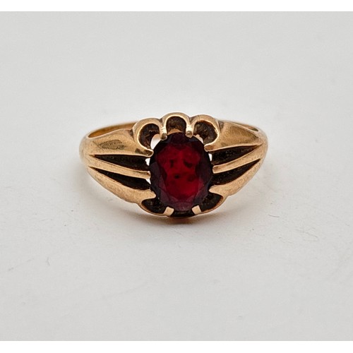 1011 - A vintage 9ct gold men's signet ring set with an oval cut garnet. Scallop edges to mount with split ... 