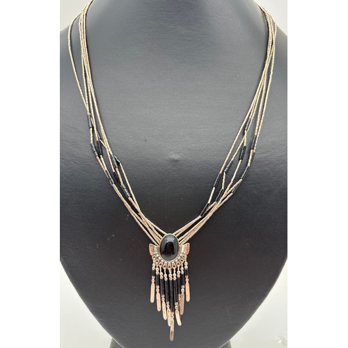 1003 - A Native American silver and onyx fixed pendant necklace possibly by Joe Quiyo. Multi strand necklac... 