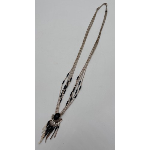 1003 - A Native American silver and onyx fixed pendant necklace possibly by Joe Quiyo. Multi strand necklac... 