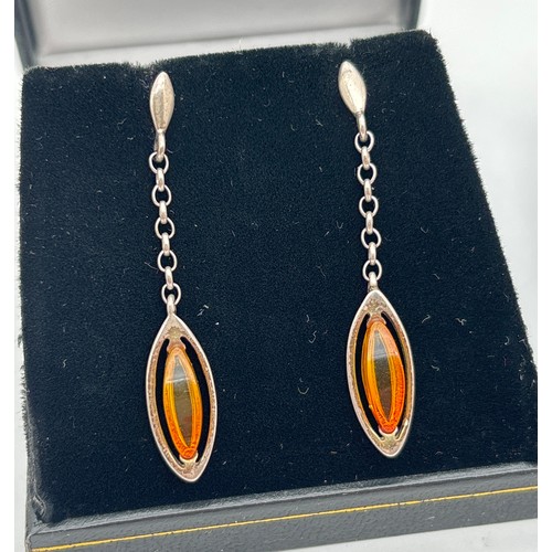1018 - 2 pairs of silver drop style amber earrings. A pair of marquise cut honey amber drops suspended from... 