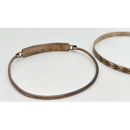 1019 - 2 silver bangles. A 5mm wide bangle with diamond cut pattern throughout, together with a thin bangle... 