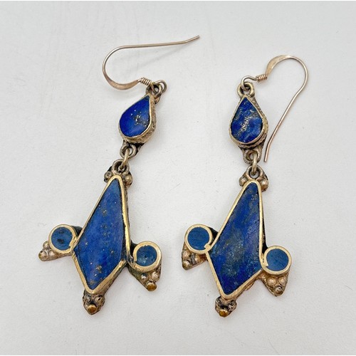 1022 - A pair of silver ethnic design drop earrings set with lapis lazuli. Hook posts marked 925. Total len... 