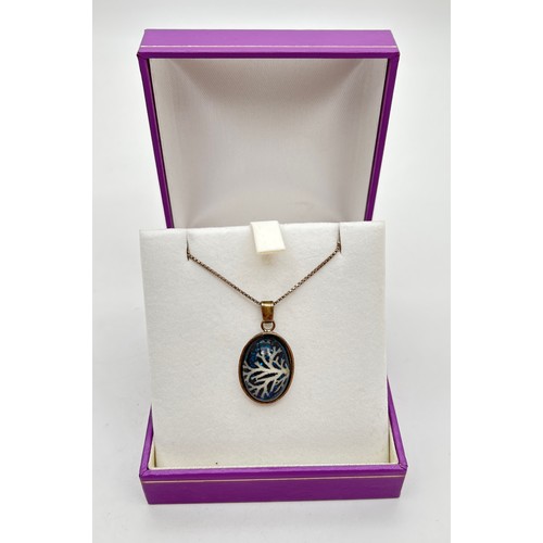 1036 - A boxed silver pendant necklace set with a small piece of white branch coral, on an 18