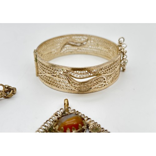 1037 - A tray of ethnic and middle eastern style metal jewellery, some set with natural agate stones. To in... 